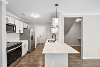 a renovated kitchen with white cabinets and stainless steel appliances at Cidermill Village Apartments in Rochester Hills, MI 